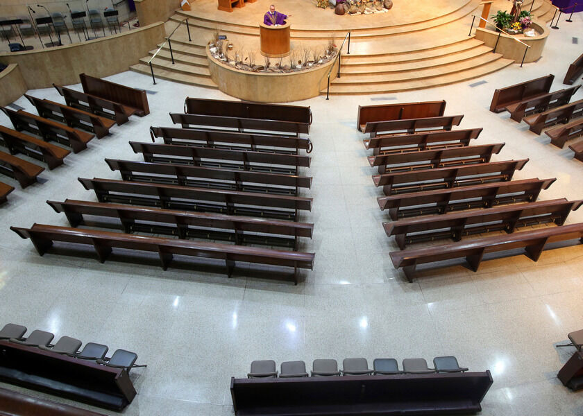 Rev. Jorge Gomez conducts morning Mass with no worshippers present at the Basilica of Our Lady of San Juan del Valle on Saturday in San Juan, Texas. The Mass was broadcast on the church’s Facebook page. The Diocese of Brownsville announced that the public will not be allowed in the church to stop the spread of the coronavirus. AP