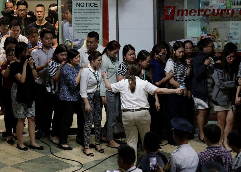 Hostages walk out at the V-Mall in Manila on Monday. AP