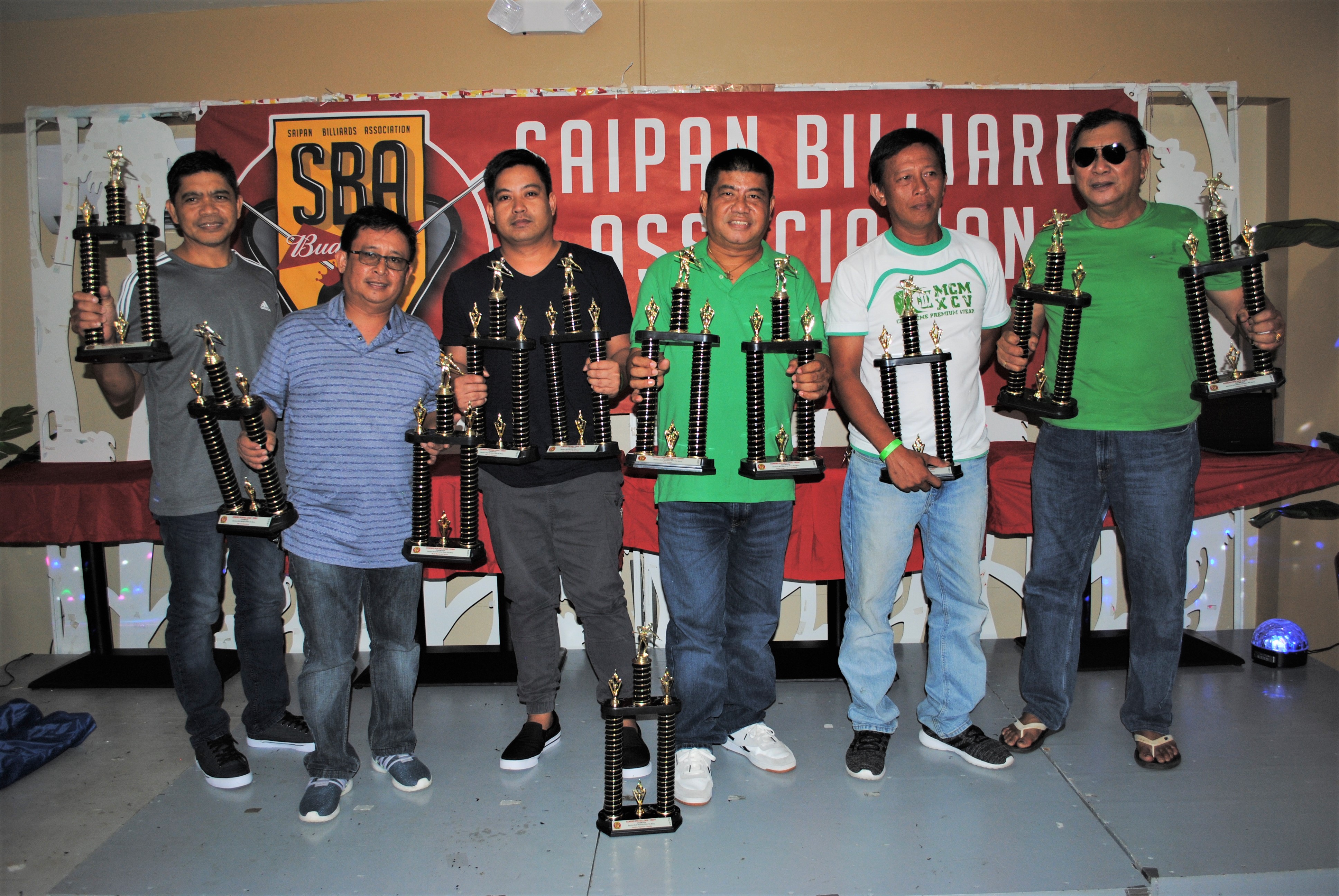 The team members of Bamboo MJD Marianas Water No Mercy pose with the Tuesday Division 1st place trophies of the SBA Budweiser Open 8-Ball League during the awards banquet at Rendezvous restaurant on Sunday.