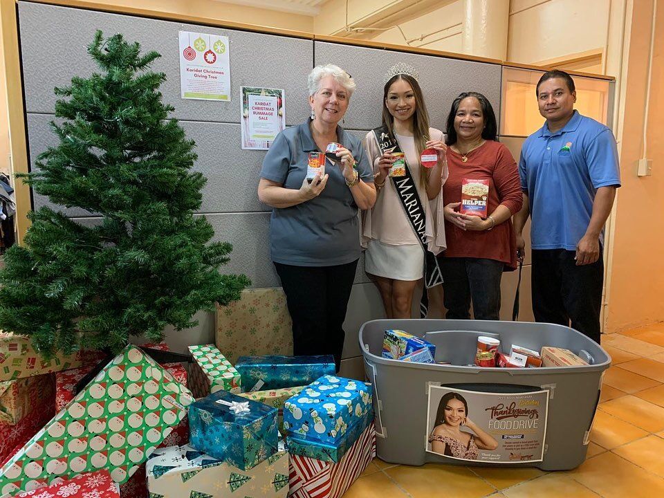 Karidat Executive Director Lauri Ogumoro, left, and other staff members join 2019 Miss Marianas Shannon Sasamoto in accepting her Thanksgiving food drive donations, in which Marianas Variety also helped promote, as part of its community service.