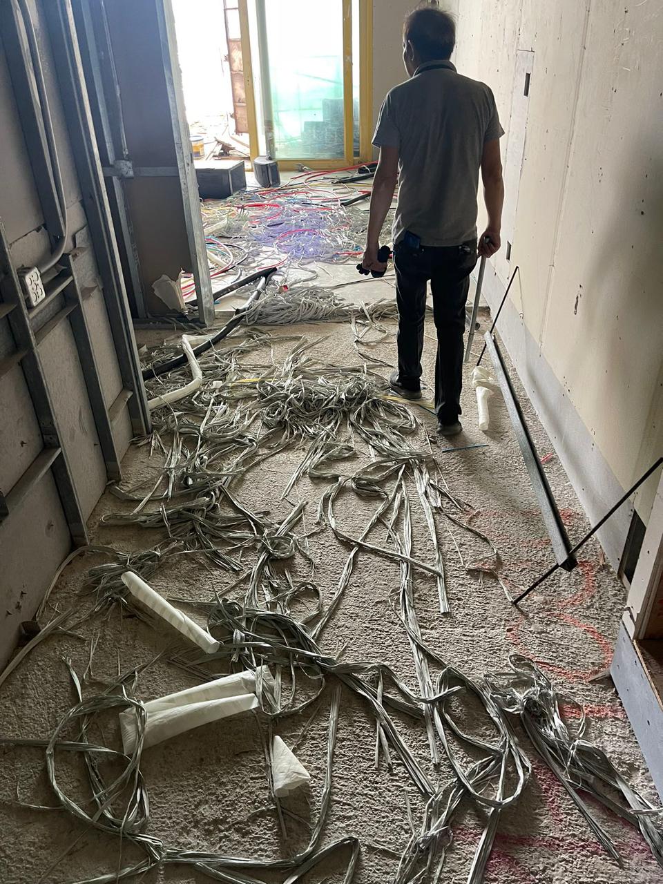 An Imperial Pacific International employee looks at the insulation stripped from copper wire on one of the IPI hotel tower floors on Dec. 5, 2022.