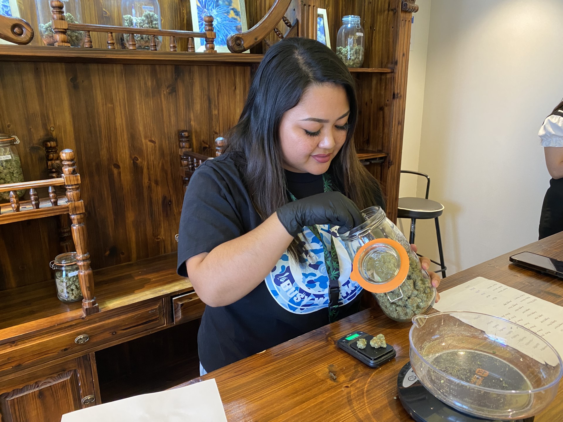 Retail manager of The Hook Up, Krissa Deleon Guerrero, measures Blueberry cannabis for a customer during the soft opening of the dispensary on Friday.