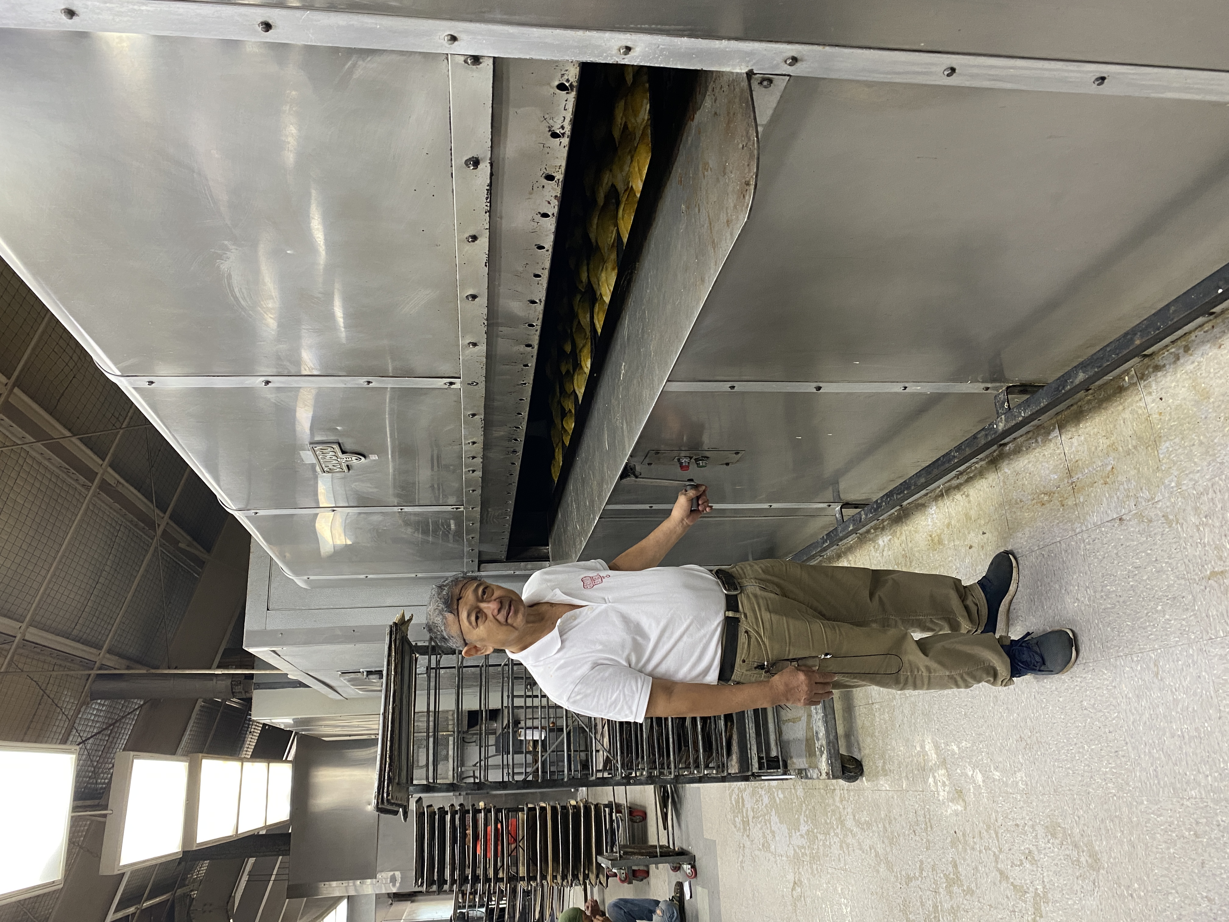 Ernie Lineses stands by one of the original Herman's Bakery commercial bread ovens. For over 40 years, Lineses has helped baked the pullman loaves, sweet bread, and cookies that the Marianas love.  