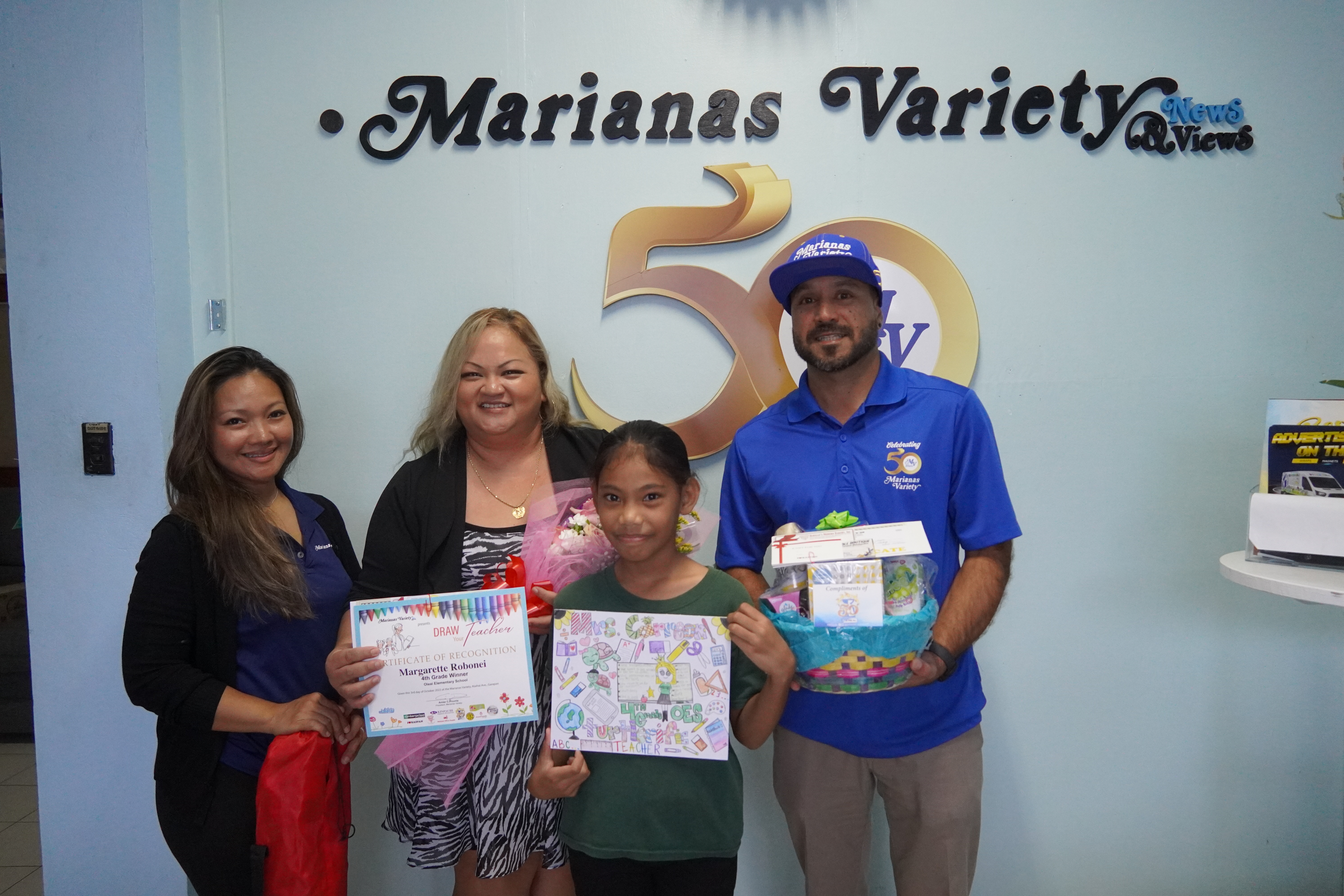 Variety President, Amier Younis, and Jennifer Younis present a prize package to fourth grader, Margarette Robonei, for her incredible iconic art piece.