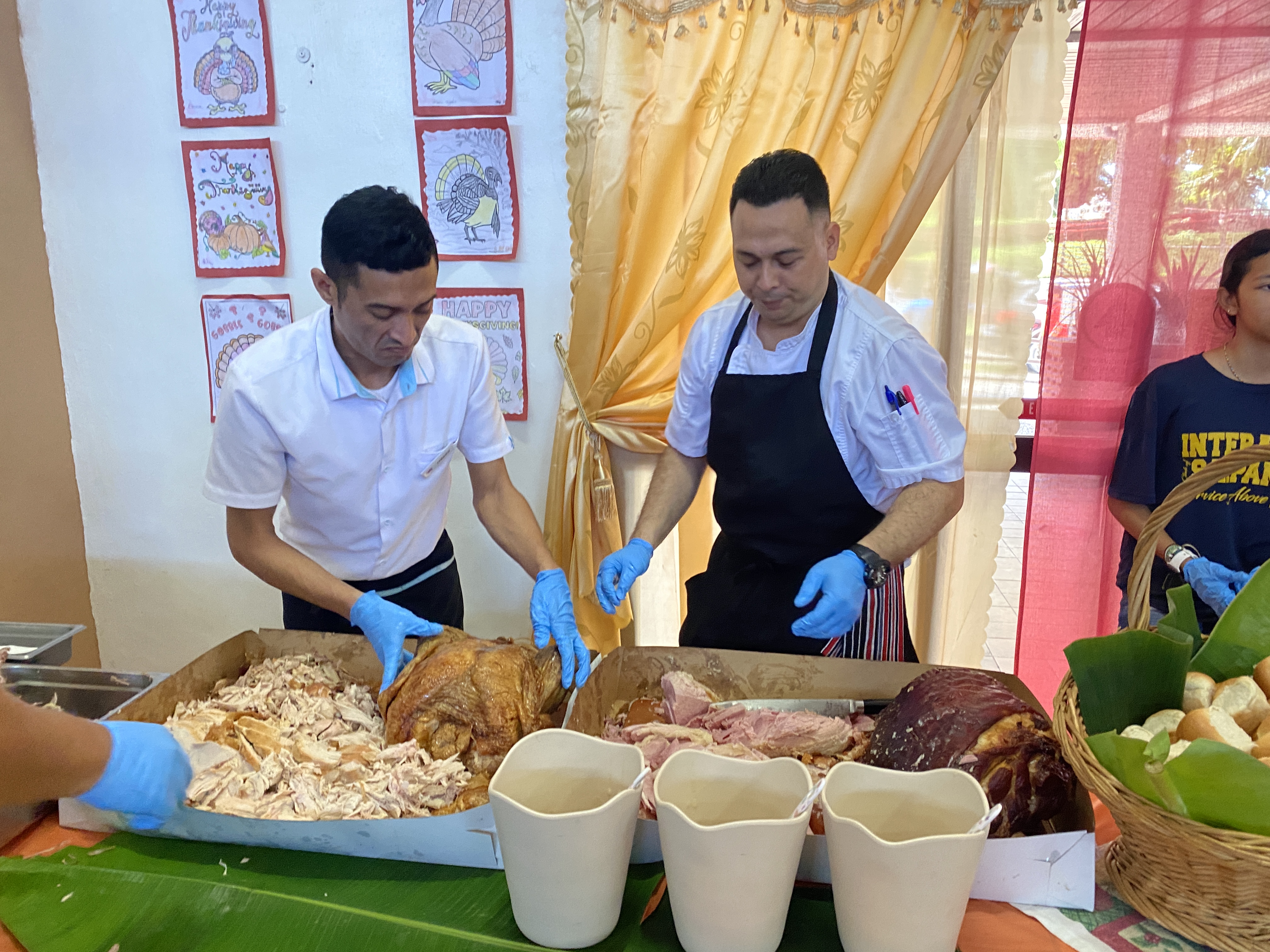 Johnny Tomei, left, and Chef Zenn Tomokane, both of Crowne Plaza Resort, man the carving station prior to serving meals at the Manamko' Center.