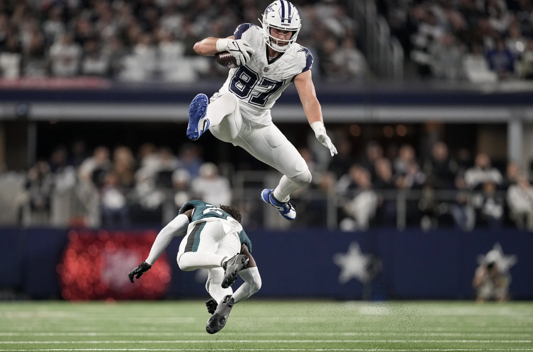 Dallas Cowboys tight end Jake Ferguson (87) leaps over Philadelphia Eagles cornerback Kelee Ringo during the second half of an NFL game, Sunday, Dec. 10, 2023 in Arlington, Texas.
