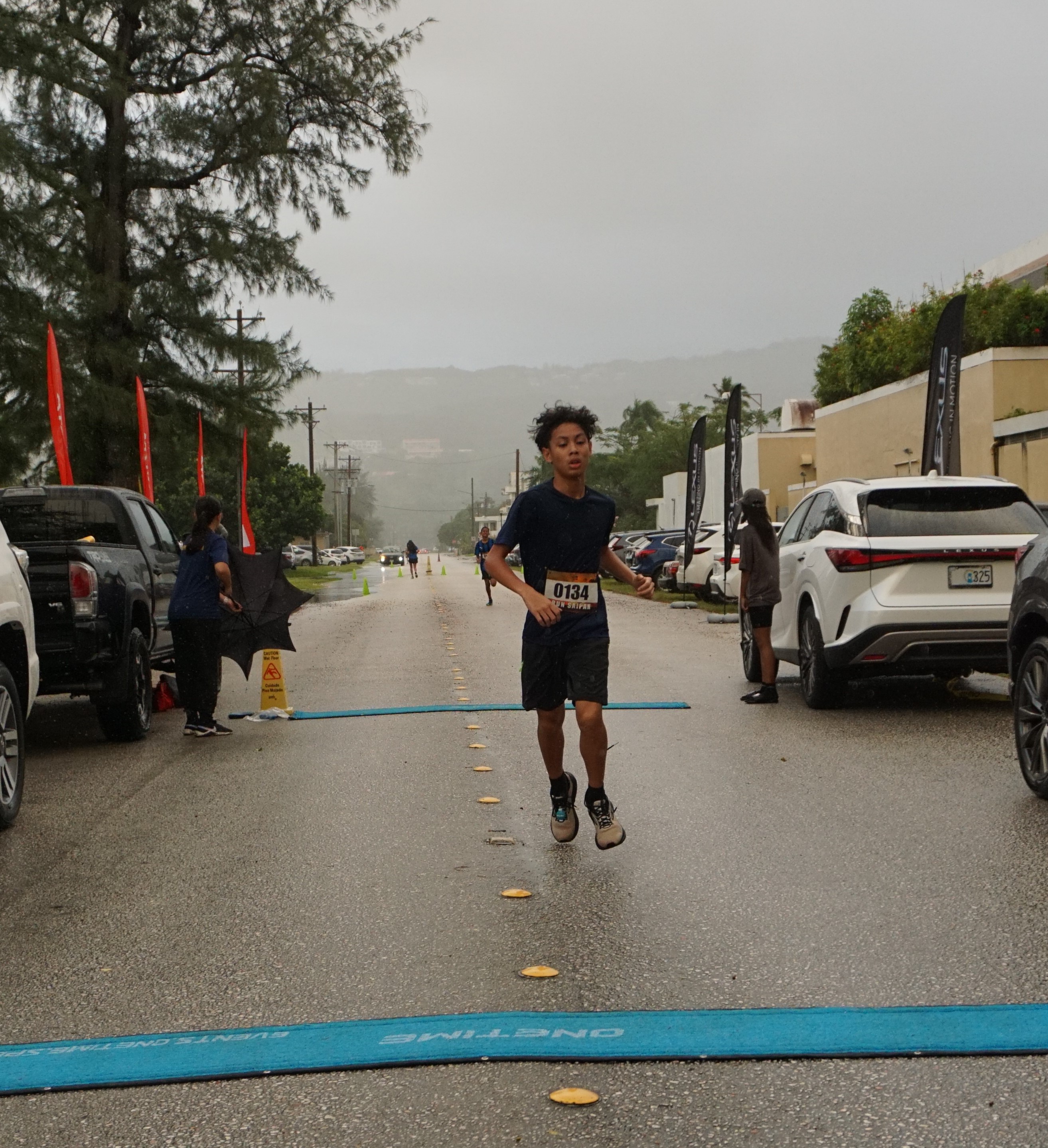 Victor Nash Santos pushes through the finish line to top the men's division of the AK 5K Fun Run on Saturday at Micro Beach.