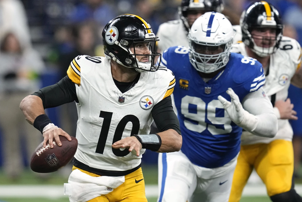 Pittsburgh Steelers quarterback Mitch Trubisky (10) rolls out, looking to pass, with Indianapolis Colts defensive tackle DeForest Buckner (99) in pursuit during the second half of an NFL game in Indianapolis on Saturday, Dec. 16, 2023.