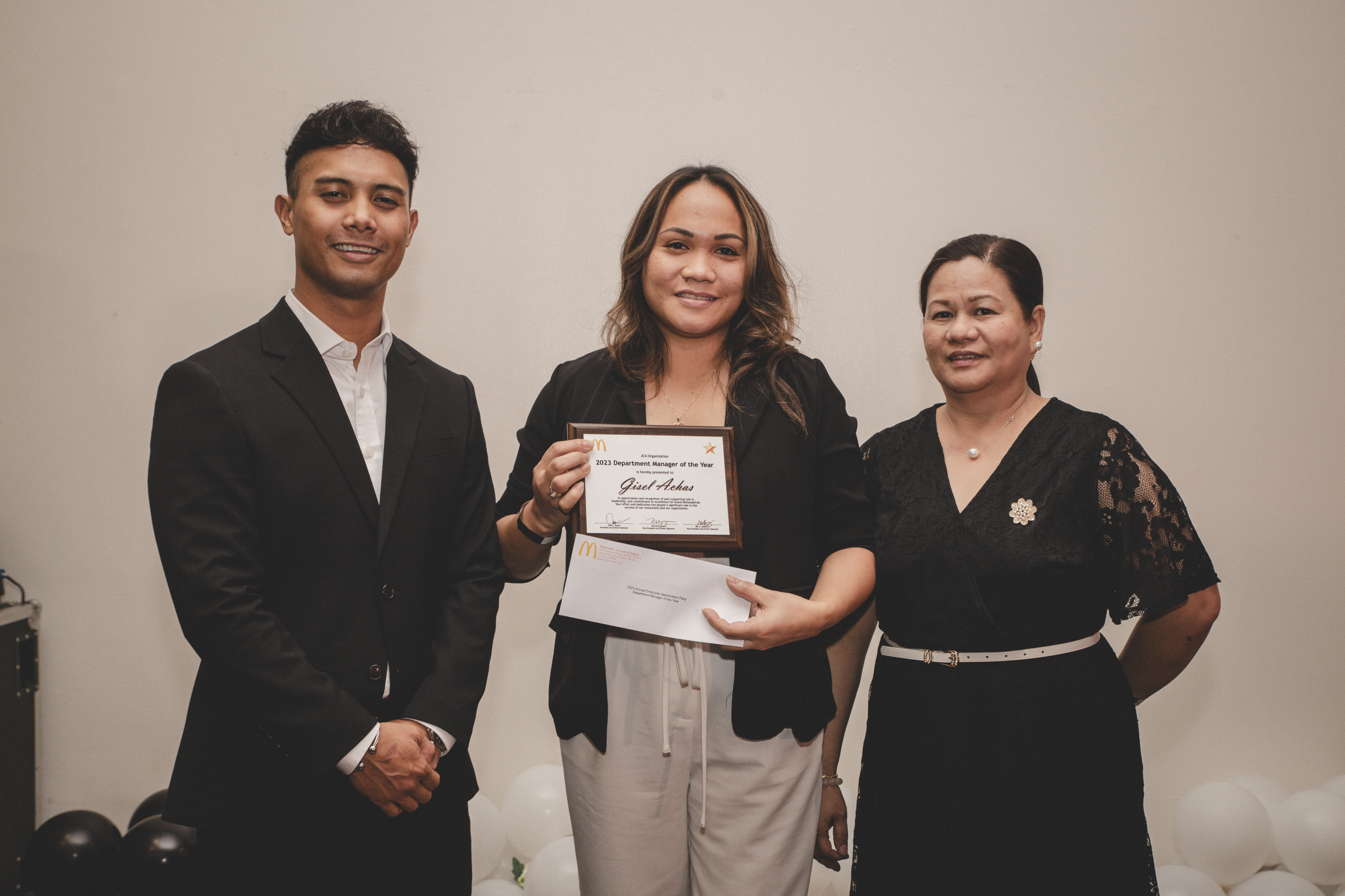 Joe Ayuyu Jr and  Joyce Asistores awards Gisel Achas as Department Manager of the Year.