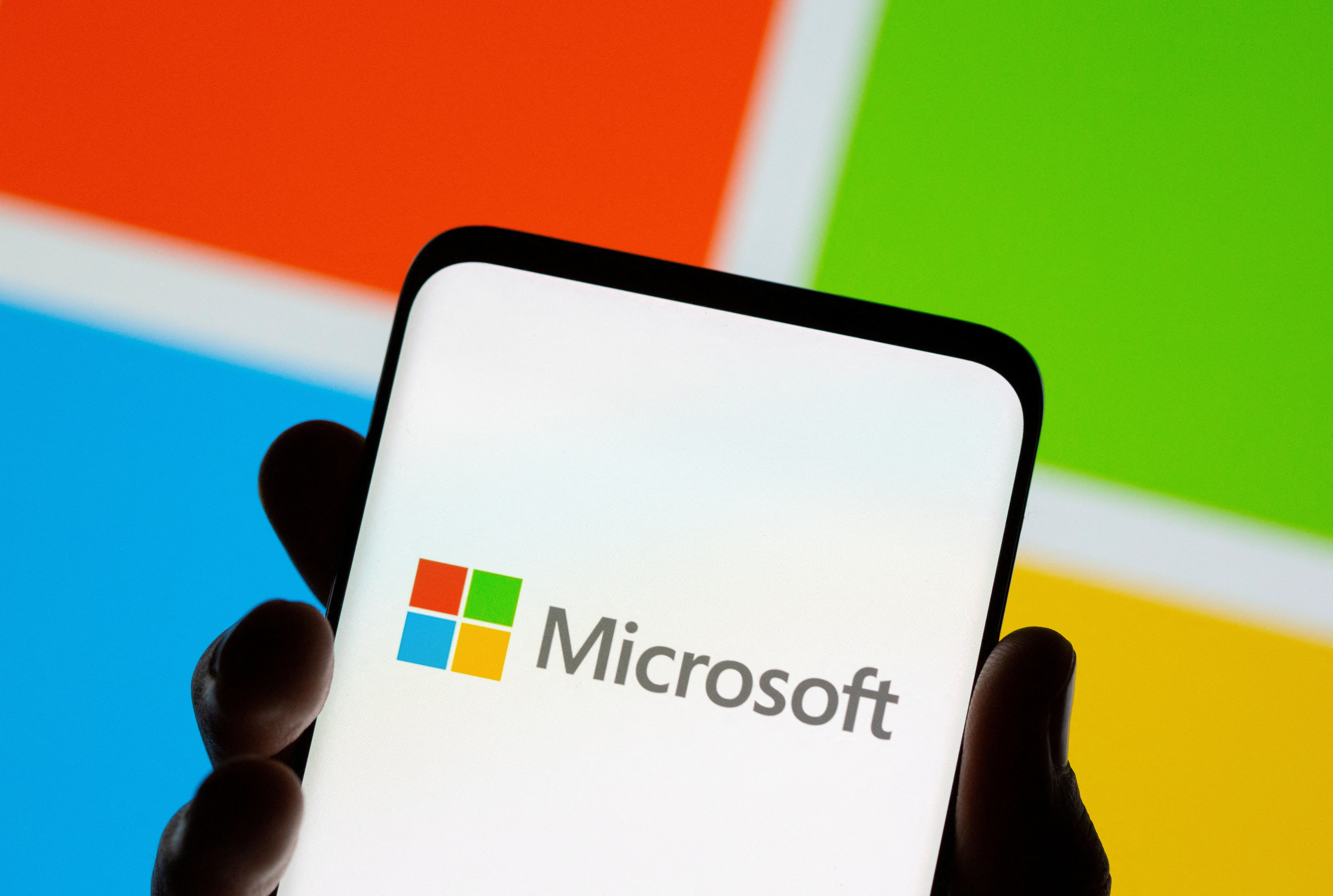FILE PHOTO: Smartphone is seen in front of Microsoft logo displayed in this illustration taken July 26, 2021. 
