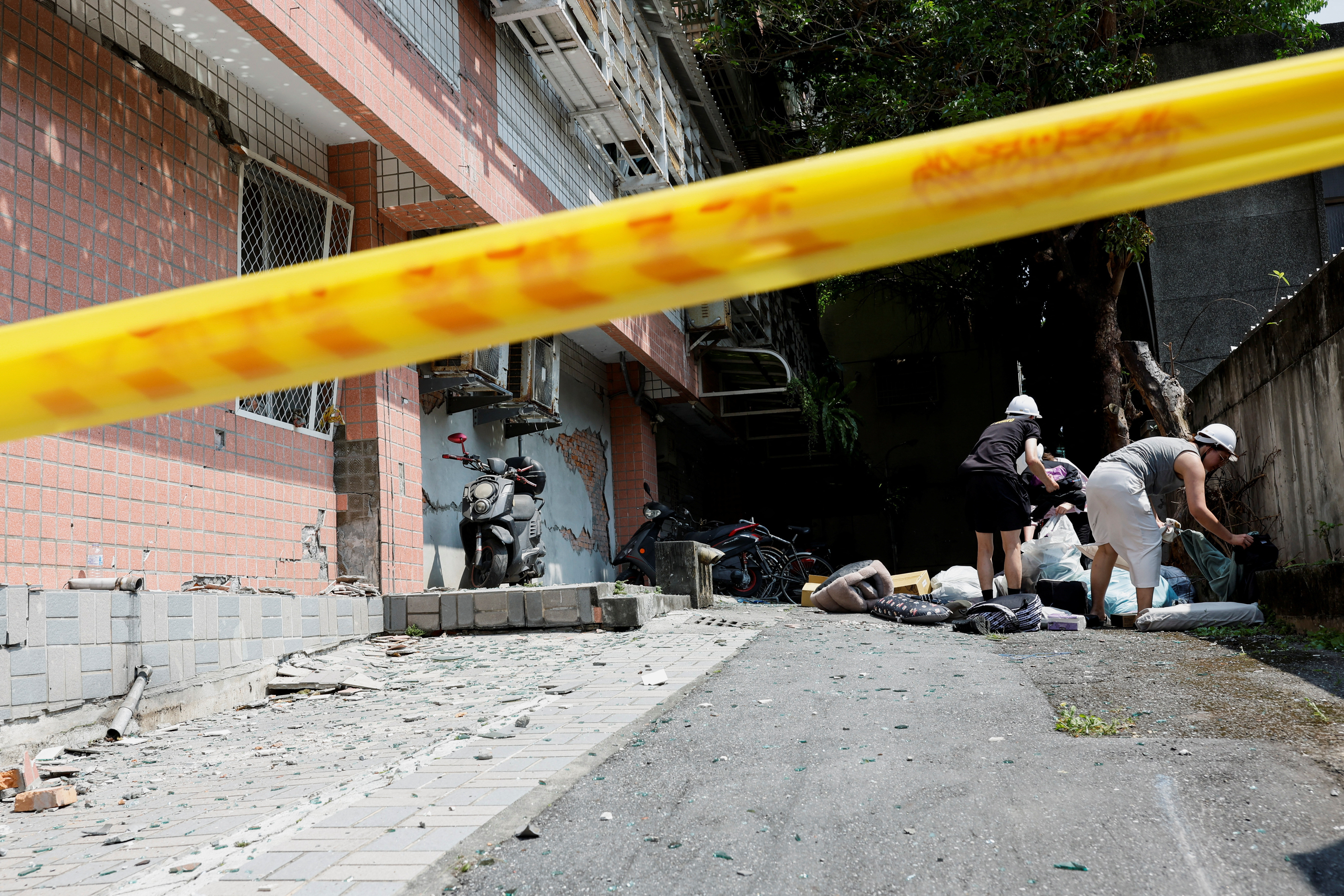 Residents collect their belongings outside a damaged building, following the earthquake, in Hualien, Taiwan, April 4, 2024. 