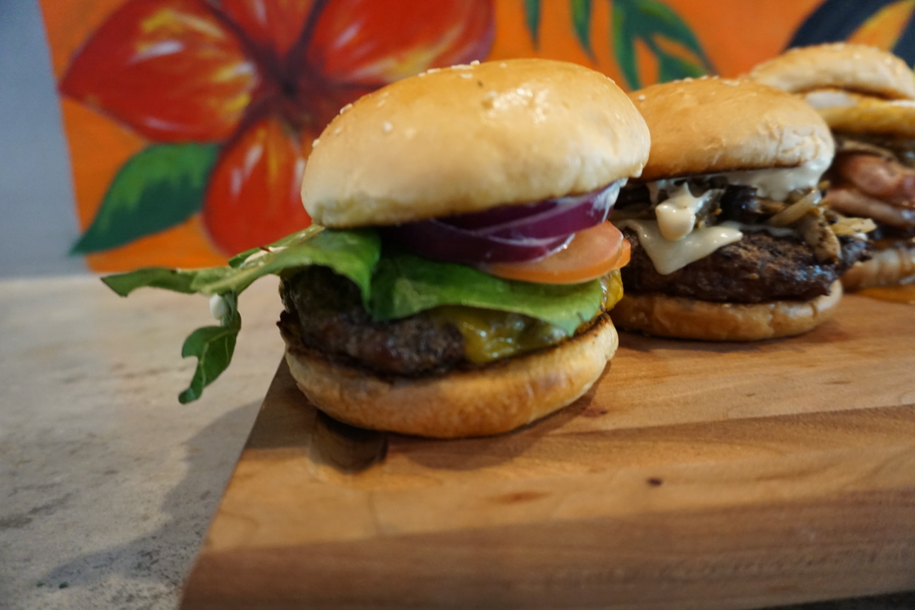 The house Cheeseburger at Inas’ Kitchen has everything you need for classic burger experience:​garlic aioli, cheddar cheese, lettuce, tomato, and onion.