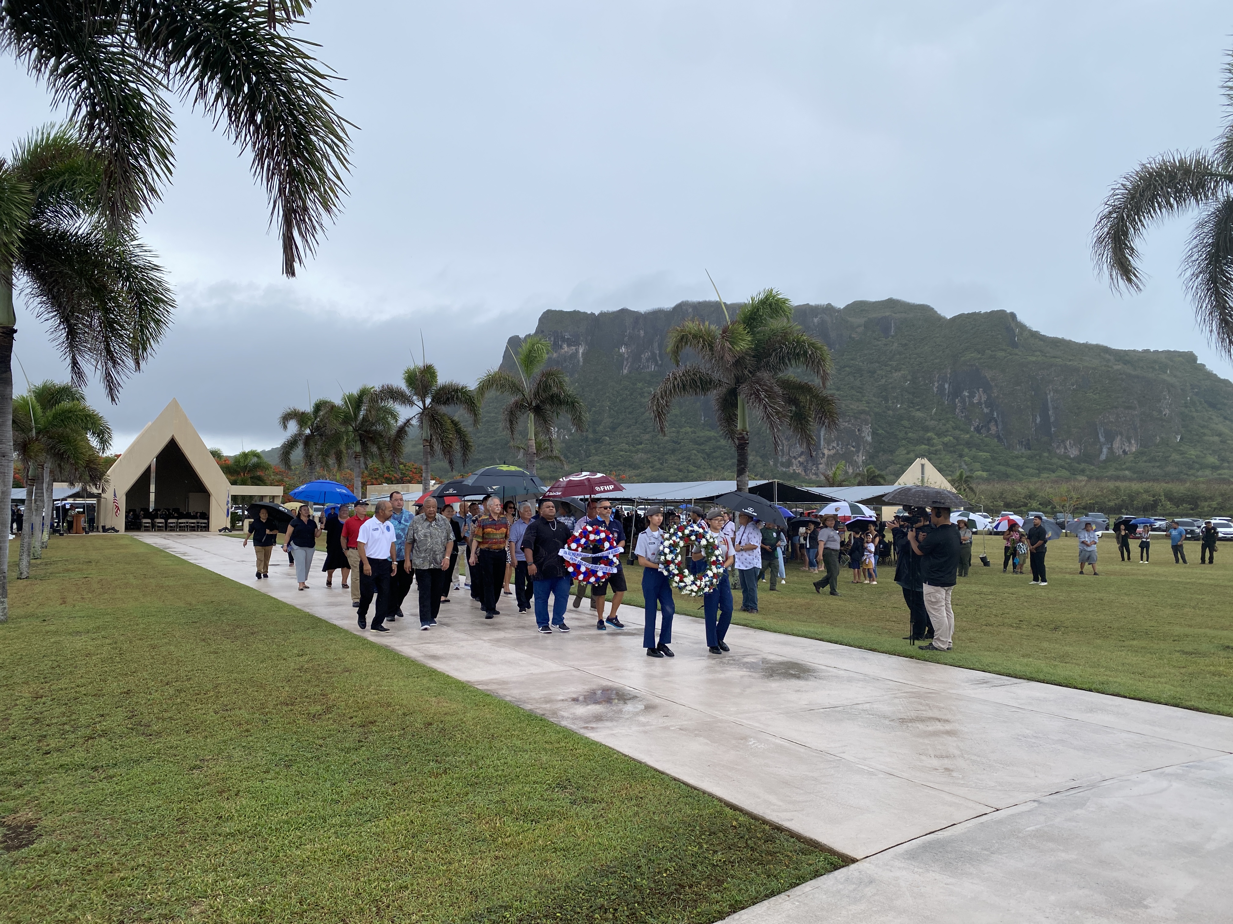 CNMI officials, veterans, servicemembers, and families of military personnel interred at the Veterans Cemetery in Marpi walk together during the wreath-laying ceremony.