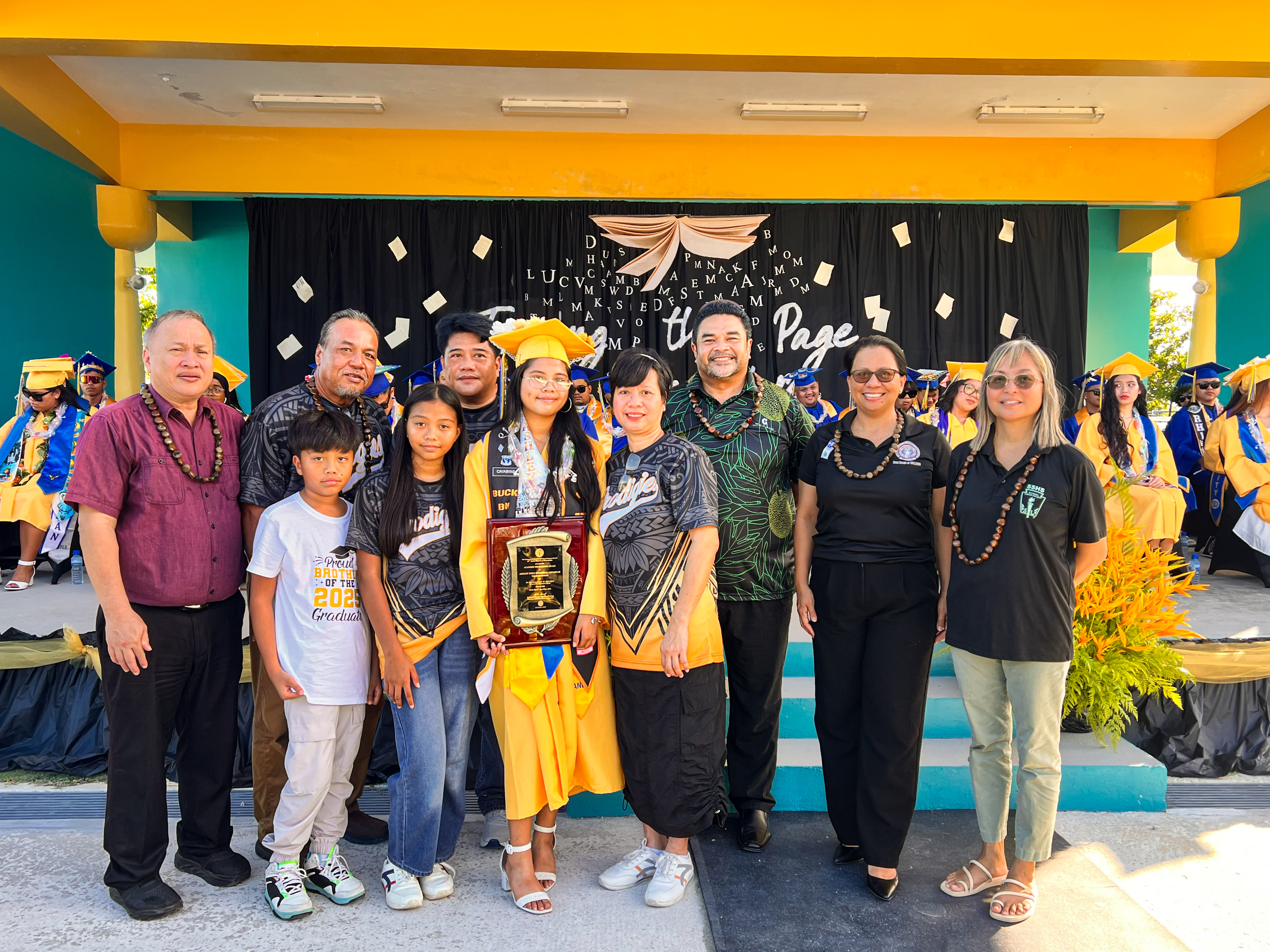 Valedictorian and recipient of the Board of Education Academic Excellence Award Ashley Kyle Esguerra Cayabyab with BOE Chairman Aschumar Kodep Ogumoro-Uludong, Vice Chairman Anthony L. Barcinas, BOE member Andrew L. Orsini, BOE member Maisie B. Tenorio, and Teacher Rep. Dr. Dora Miura.