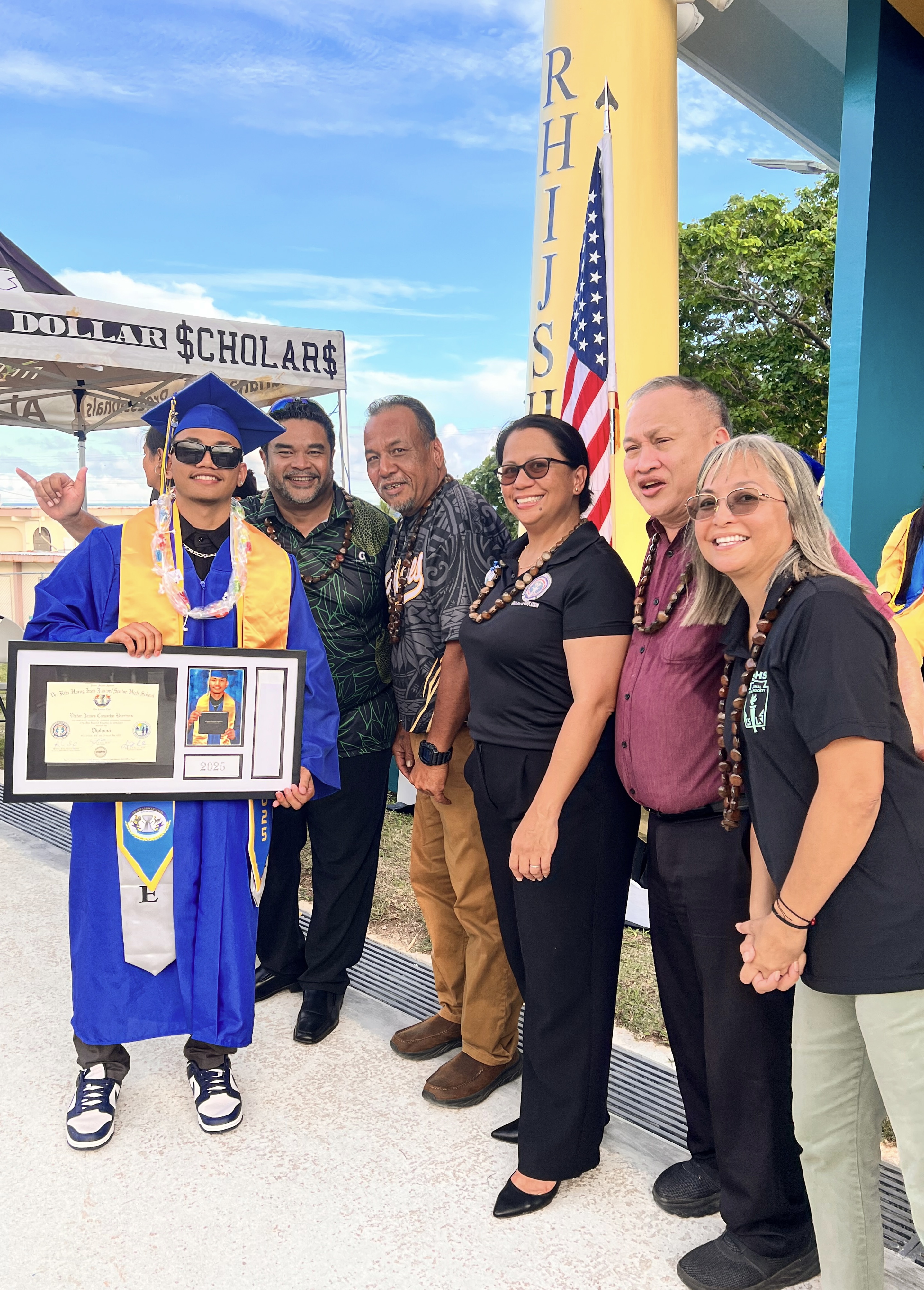 Victor James Camacho Barcinas poses for a photo with his father, Board of Education Vice Chairman Anthony Barcinas, BOE Chairman Aschumar Kodep Ogumoro-Uludong, BOE member Andrew L. Orsini, BOE member Maisie B. Tenorio, and Teacher Rep. Dr. Dora Miura.