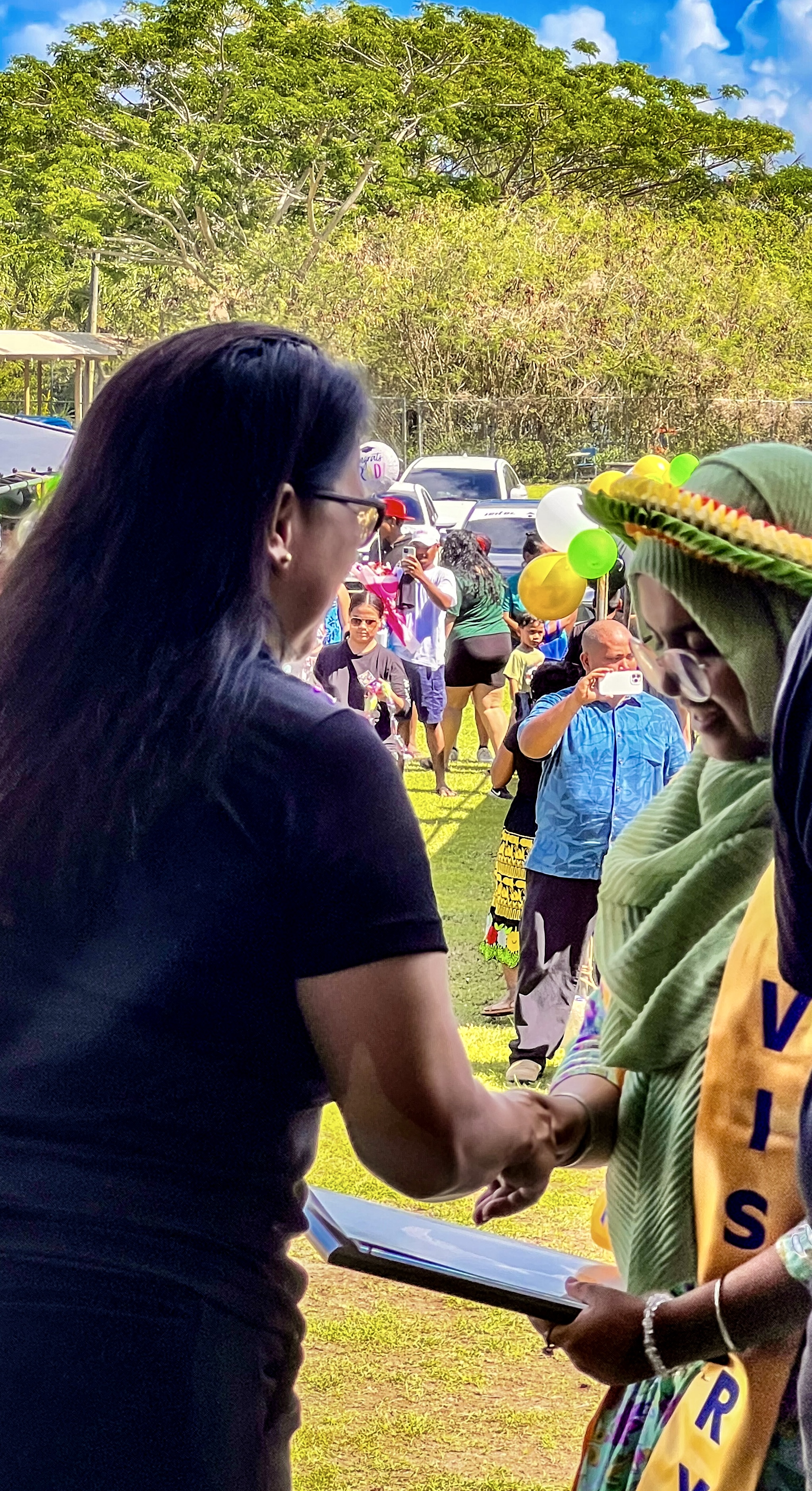 BOE member Maisie B. Tenorio congratulates a promoted student.