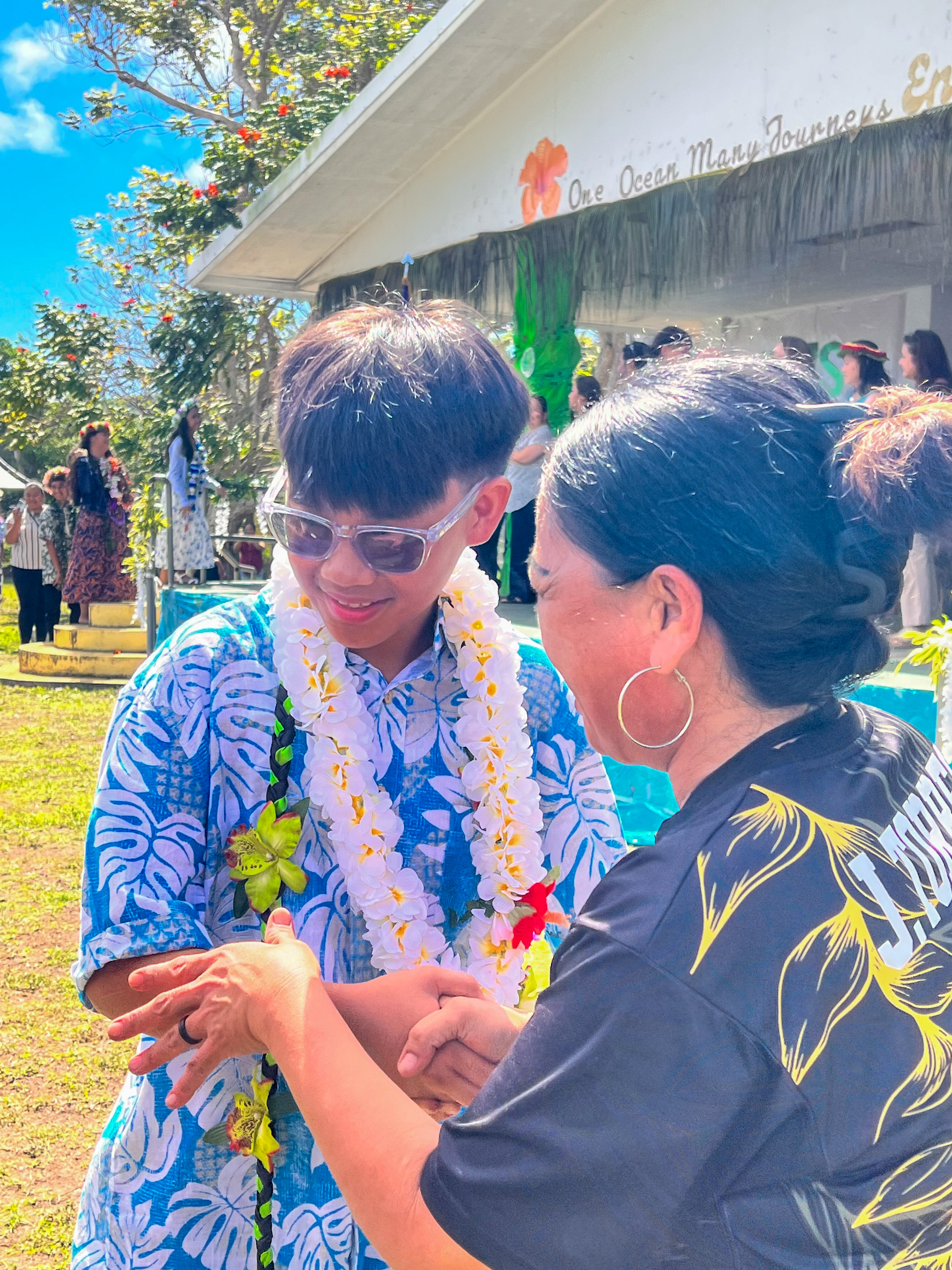 A promoted student is congratulated by his TMS teacher.