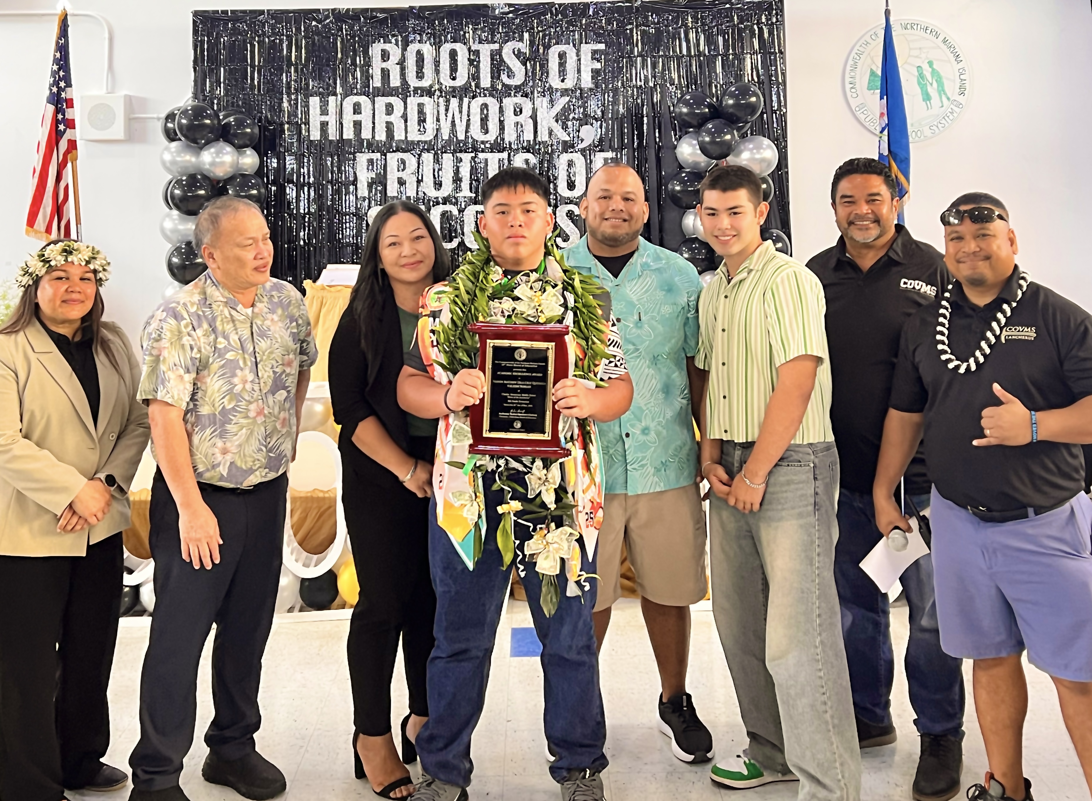 Valedictorian Vashon Matthew Dela Cruz Quitugua with Board of Education Chairman Aschumar Kodep Ogumoro-Uludong, BOE member Andrew L. Orsini, and Student Representative Vinnie Juan Q. Sablan. Also in photo are Quitugua’s parents, Maria and Oswald Quitugua, both hardworking PSS employees, along with COVMS Principal Carla Sablan and Vice Principal Dr. Ben Seman.