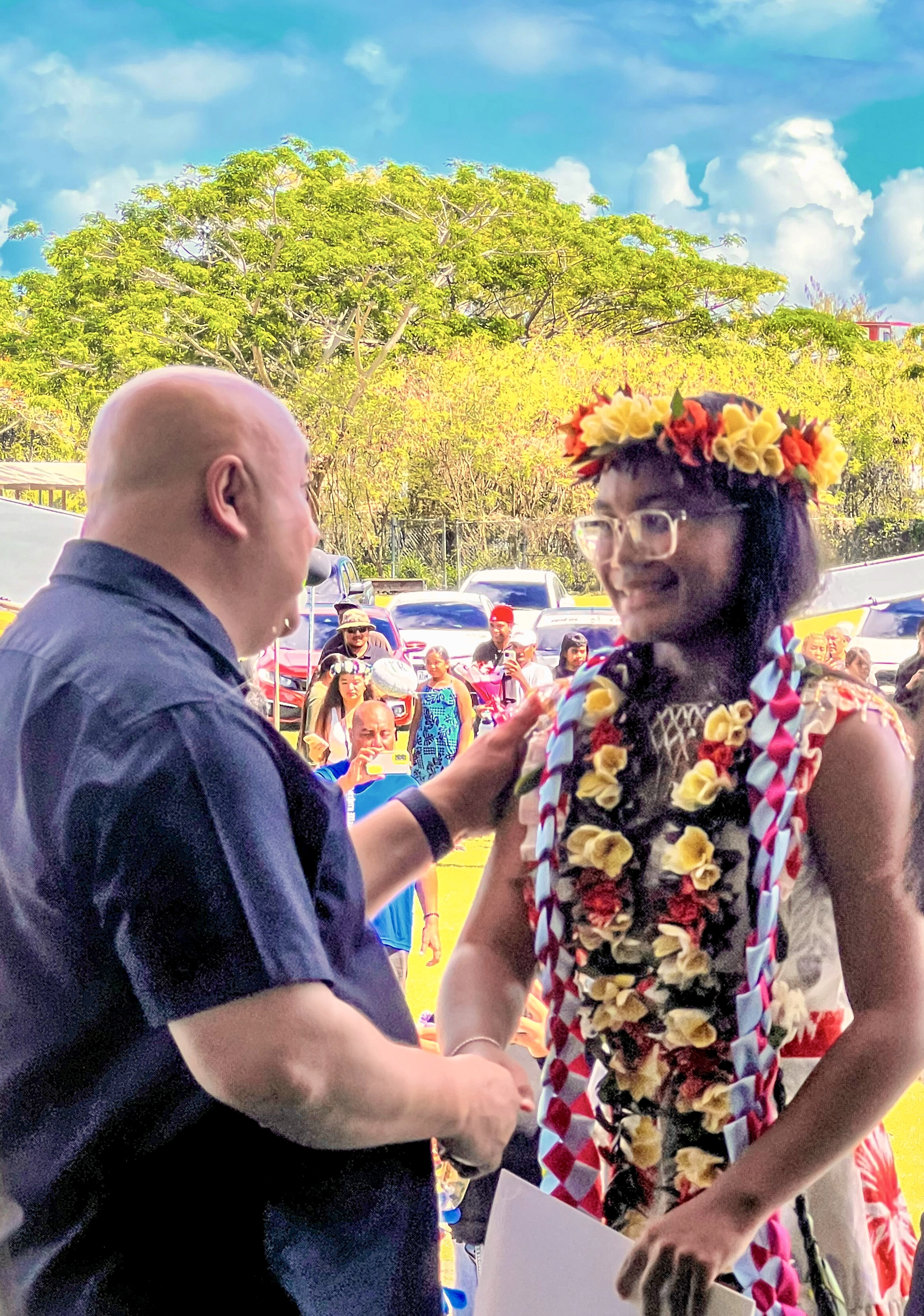 Commissioner of Education Dr. Lawrence F. Camacho extends his congratulations to a promoted student.