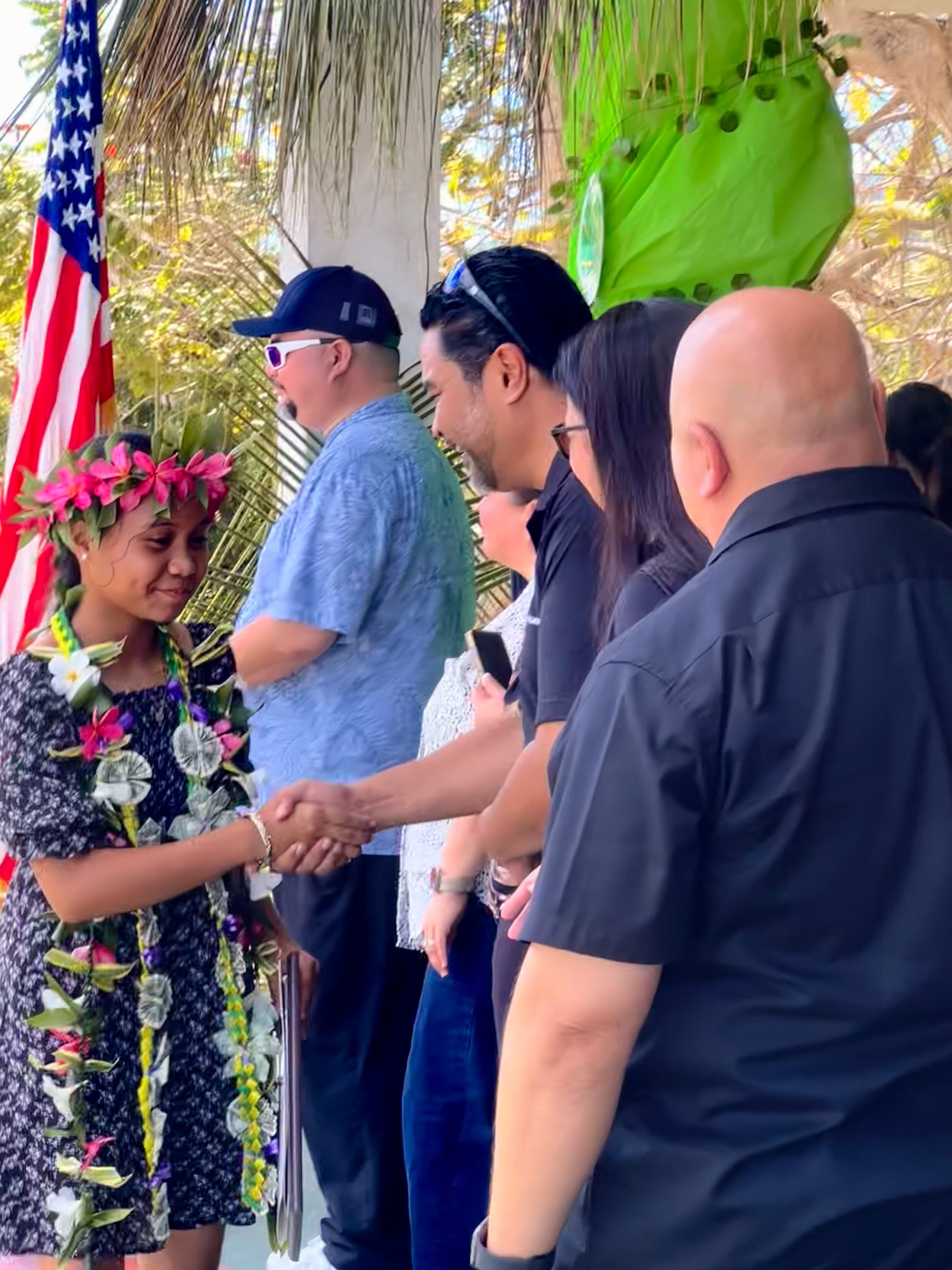 Principal Vic Borja, BOE Chairman Aschumear Kodep Ogumoro-Uludong, BOE member Maisie B. Tenorio and Commissioner of Education Dr. Lawrence F. Camacho congratulate valedictorian Cheyenne Joy S. Camacho after receiving her certificate of promotion.
