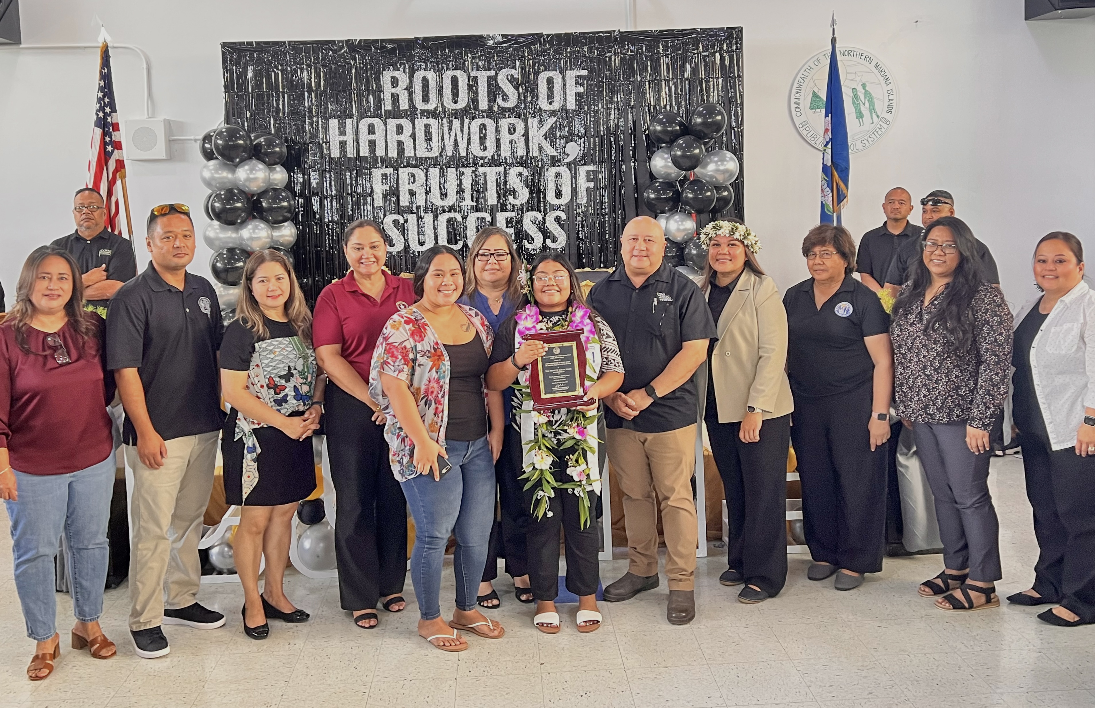 Class salutatorian Tini Monette Sablan Wabol, center, with Commissioner of Education Dr. Lawrence F. Camacho, other PSS officials and COVMS administrators.